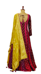 Traditional Anarkali outfit with yellow dupatta and pink and red embroidered dress on a mannequin against a plain background.