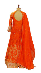 Orange traditional Anarkali outfit with gold embroidery on a mannequin against a neutral background