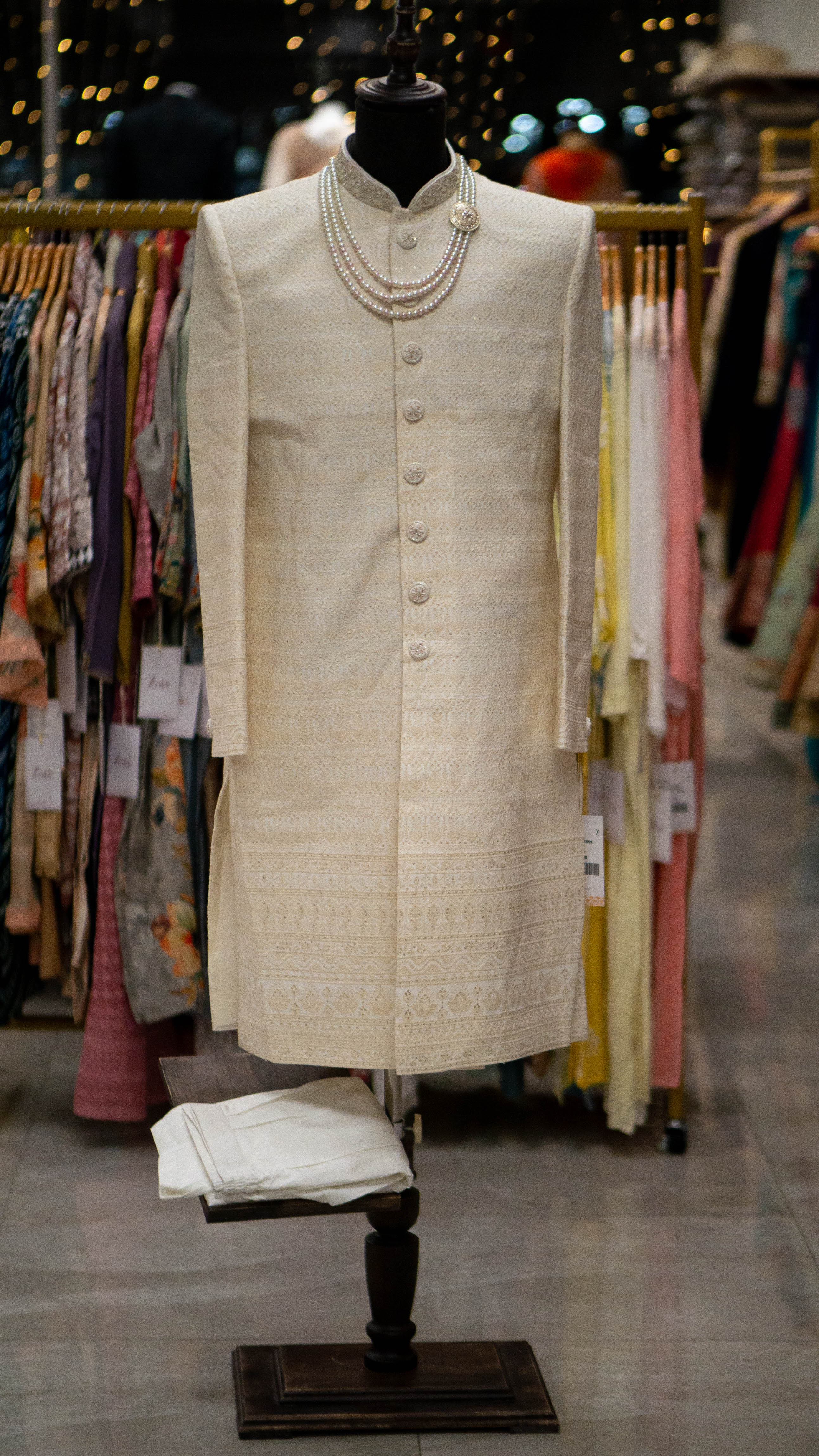 Traditional Ivory colored Sherwani on a mannequin in a clothing store setting