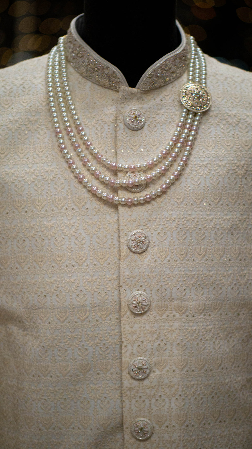 Pearl necklace on a mannequin wearing a Ivory colored Sherwani.