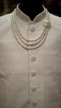 Pearl necklace on a mannequin wearing a Ivory colored Sherwani.