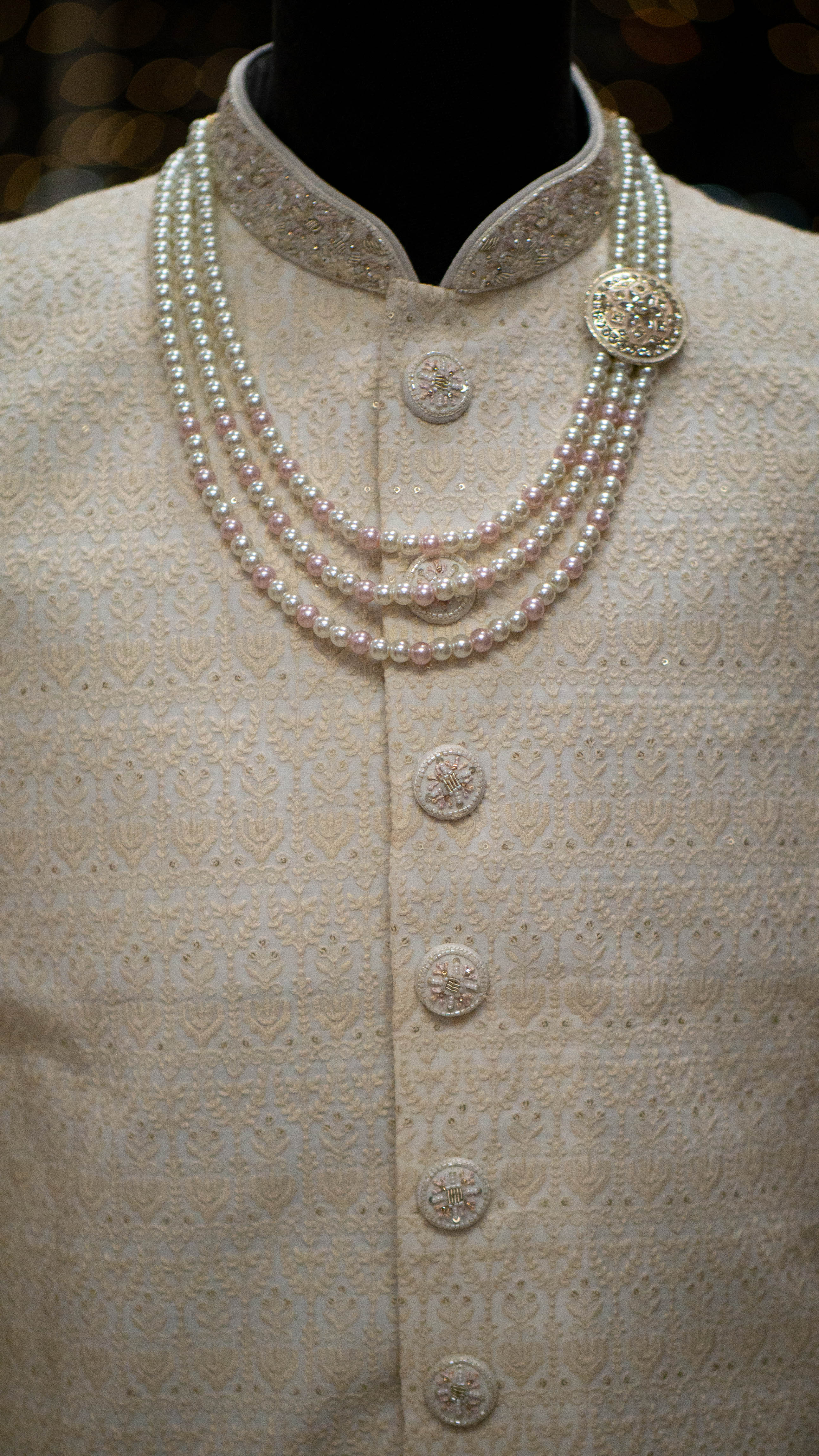 Pearl necklace on a mannequin wearing a Ivory colored Sherwani.