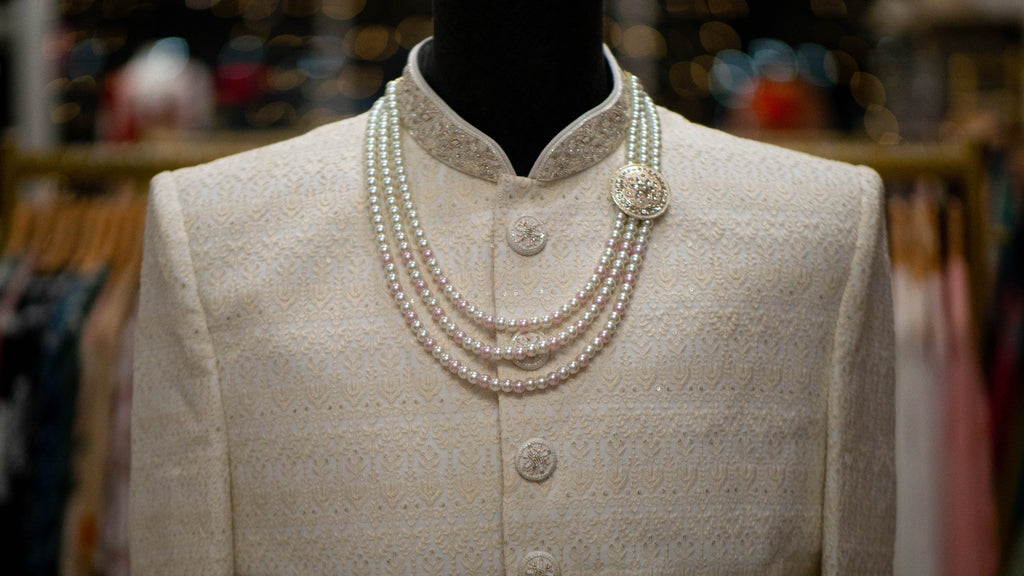 Mannequin wearing a Ivory Sherwani with pearl necklace