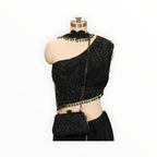 Zari Designs black drape saree featuring intricate floral embroidery, a high neck collar, and green bead embellishments.