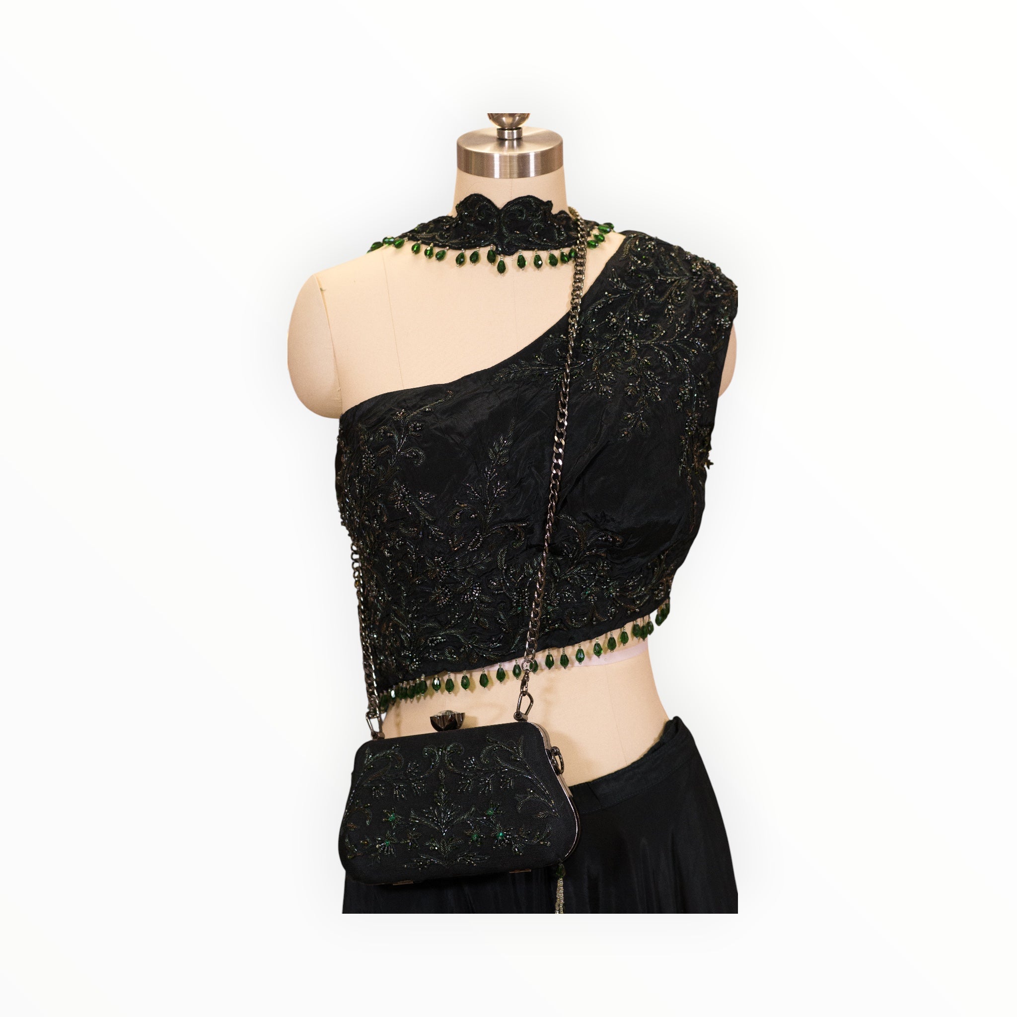 Zari Designs black drape saree featuring intricate floral embroidery, a high neck collar, and green bead embellishments.