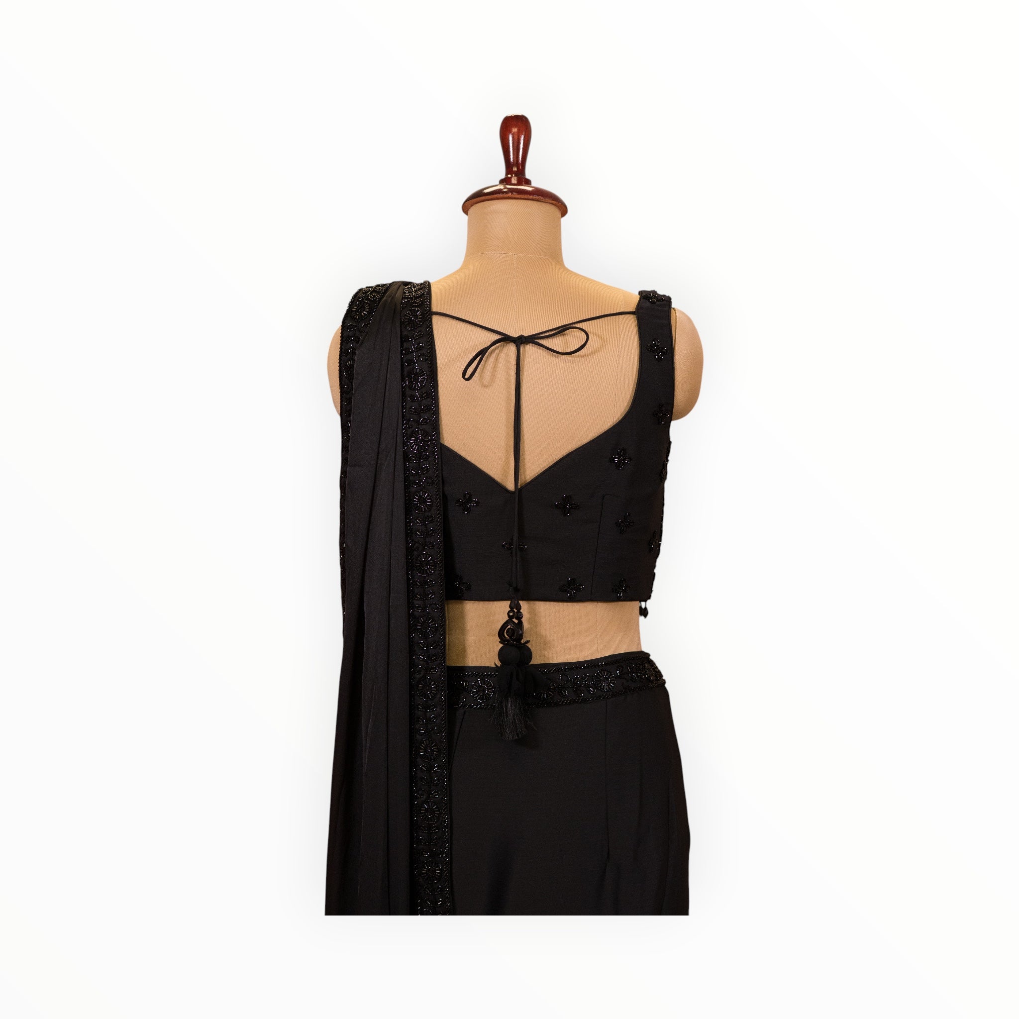 Zari Designs black ready-to-wear saree with a sleeveless blouse featuring beaded embroidery and a back tie detail.