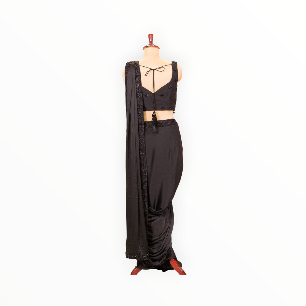 Zari Designs black ready-to-wear saree with a sleeveless blouse, featuring sequin border and back tie-up detail.
