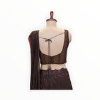 Zari Designs dark brown ready saree with a sheer sleeveless blouse featuring a tie-back detail and sequin embellishments.