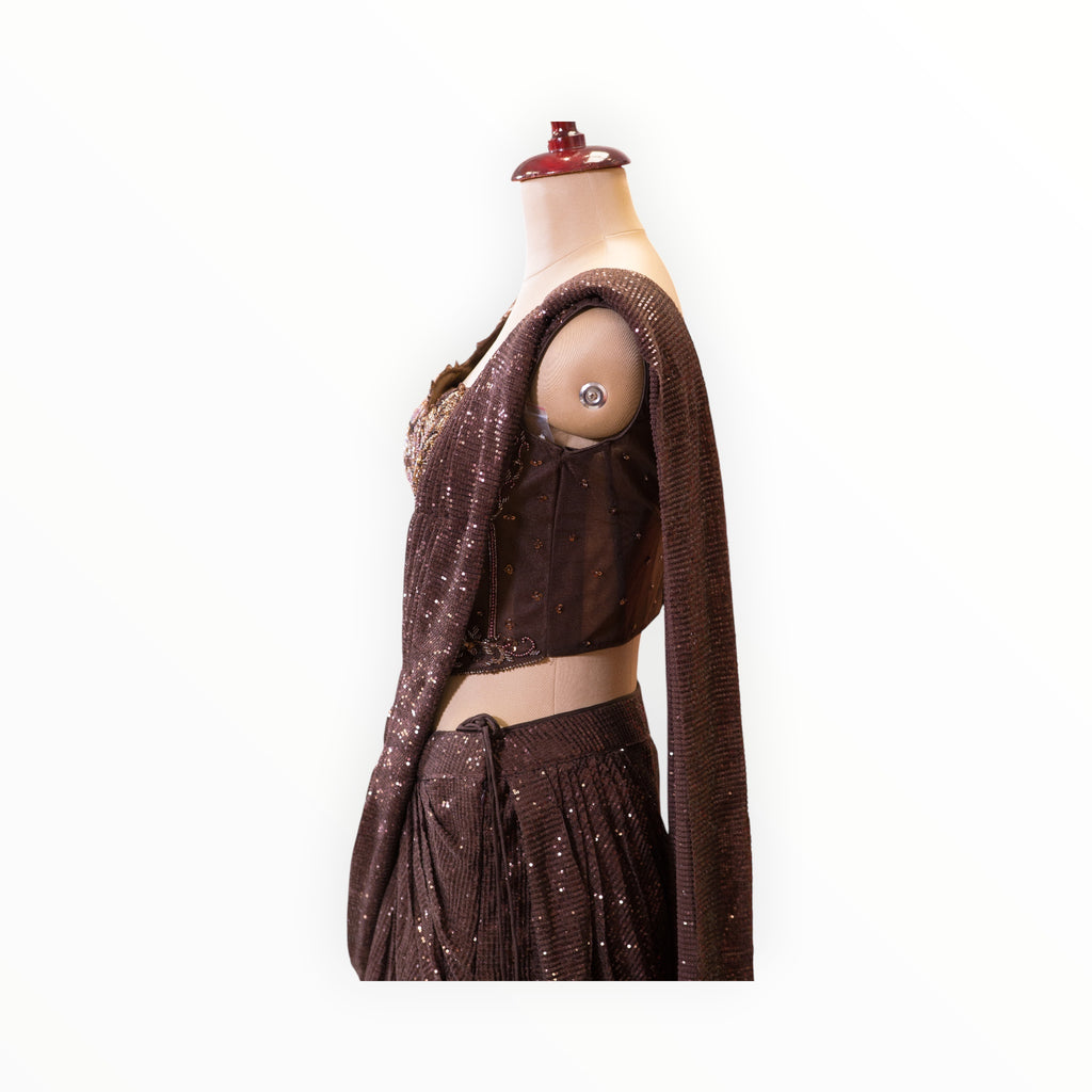 Zari Designs dark brown ready-to-wear saree featuring intricate sequin embroidery and a sleeveless blouse on a mannequin