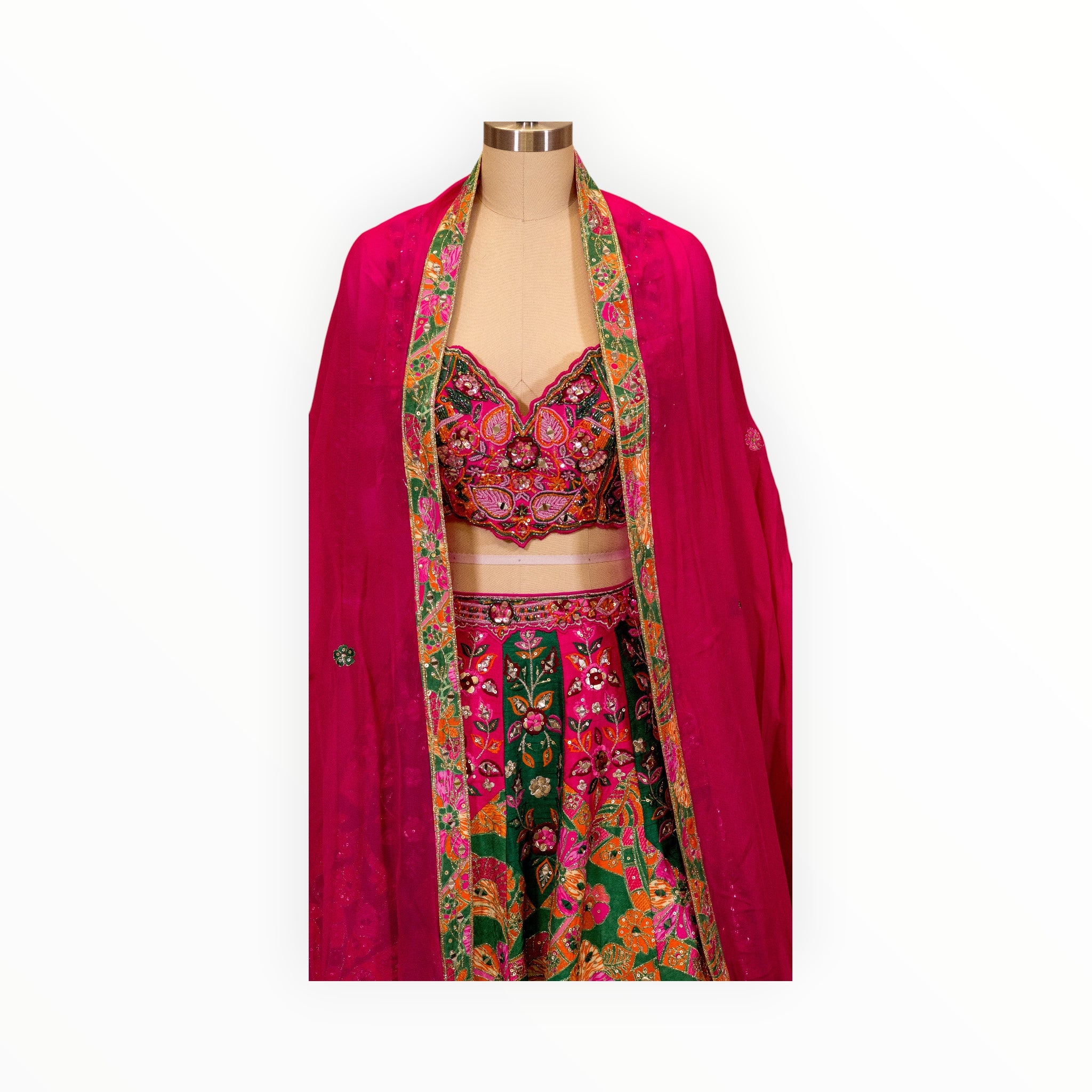 Zari Designs Carnival Lehnga featuring a vibrant pink and green skirt and blouse with intricate floral embroidery.