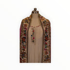 Zari Designs cream Anarkali dress featuring intricate floral embroidery and a colorful carnival-themed dupatta
