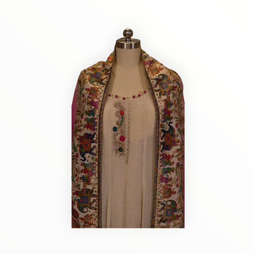 Zari Designs cream Anarkali dress featuring intricate floral embroidery and a colorful carnival-themed dupatta