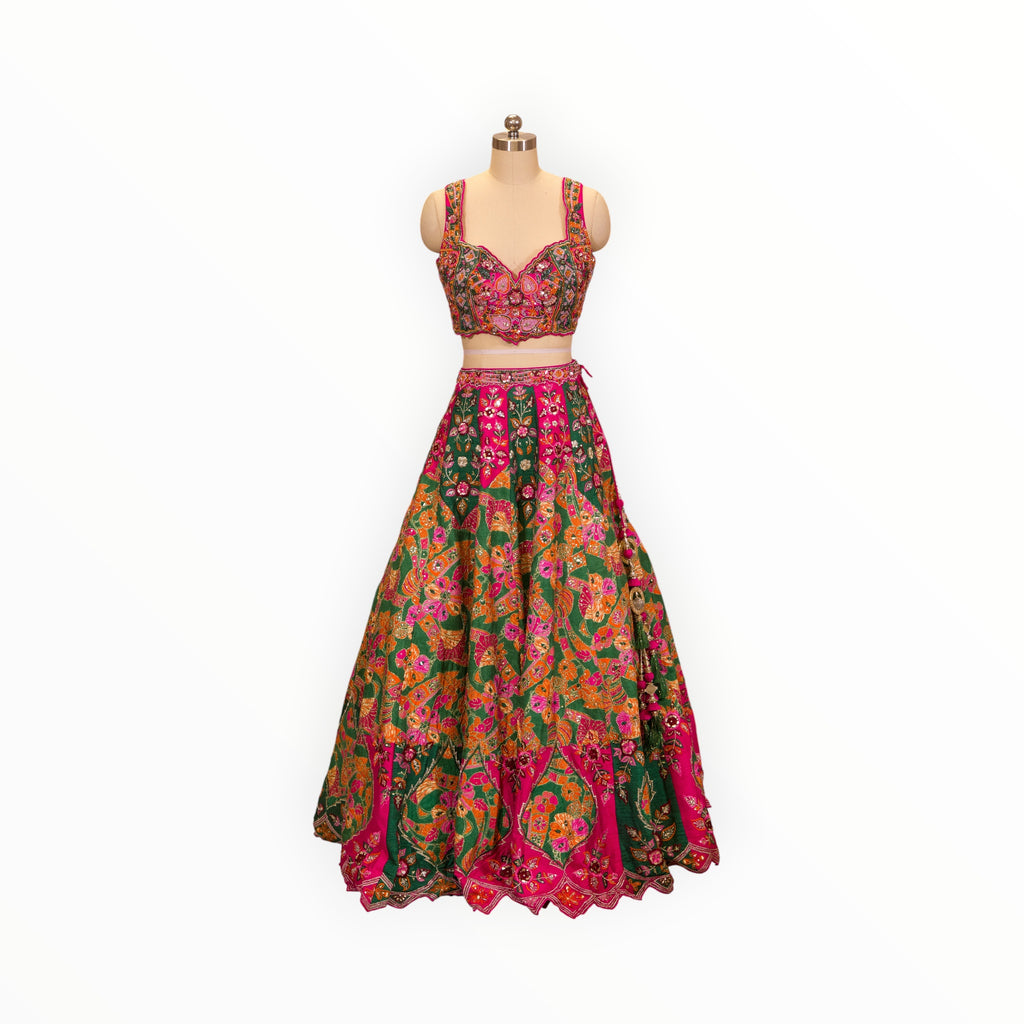 Zari Designs Carnival Lehnga featuring a vibrant pink and green floral embroidered crop top and matching flared skirt.