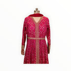 Zari Designs fuchsia pink Anarkali dress with intricate gold embroidery, mirror work, and a matching red dupatta.