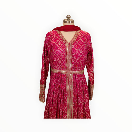 Zari Designs fuchsia pink Anarkali dress with intricate gold embroidery, mirror work, and a matching red dupatta.