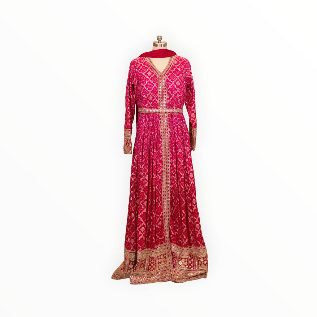 Zari Designs fuchsia pink Anarkali dress with intricate gold embroidery, bandhani print, and a matching dupatta.