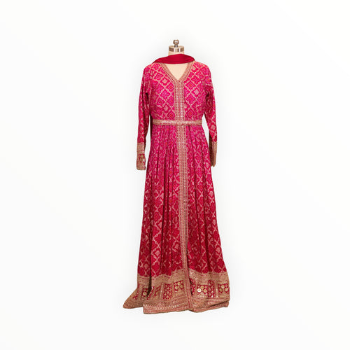 Zari Designs fuchsia pink Anarkali dress with intricate gold embroidery, bandhani print, and a matching dupatta.
