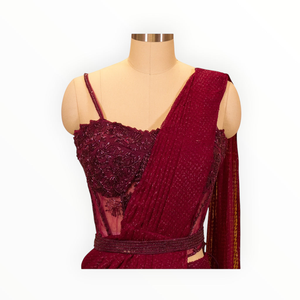Zari Designs maroon drape saree featuring a heavily embroidered corset-style bodice and textured fabric on a mannequin