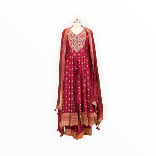 Zari Designs maroon Anarkali suit with intricate gold embroidery, V-neckline, and matching dupatta on a mannequin