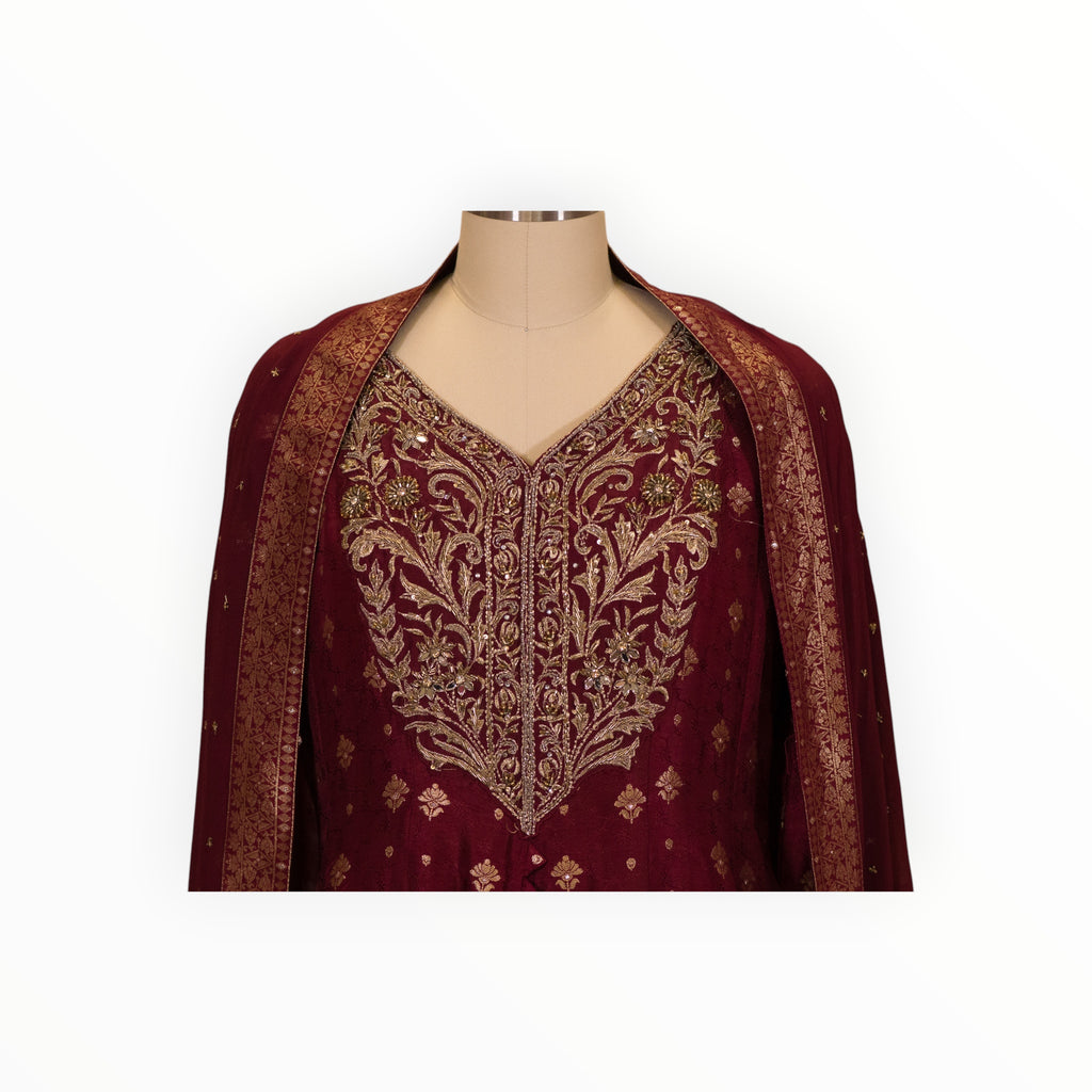 Zari Designs maroon Anarkali dress featuring intricate gold embroidery and a matching dupatta on a mannequin.
