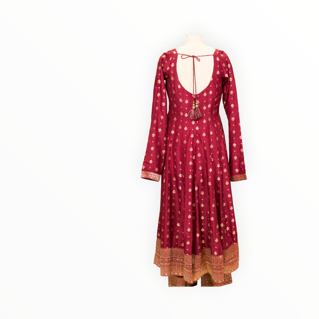 Zari Designs maroon Anarkali dress with gold floral motifs, long sleeves, and a deep back with tassel tie-up detail.