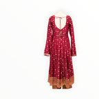 Zari Designs maroon Anarkali dress with gold floral motifs, long sleeves, and a deep back with tassel tie-up detail.