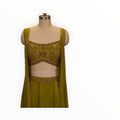 Zari Designs olive green drape saree featuring a sleeveless blouse with intricate floral embroidery and beadwork.