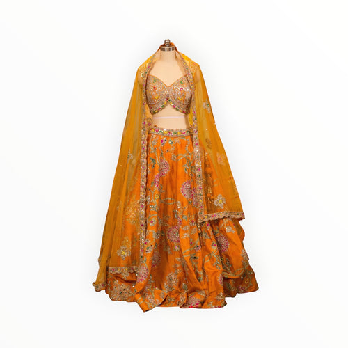 Zari Designs orange Carnival Lehnga with intricate floral embroidery, mirror work, and a matching sheer yellow dupatta.