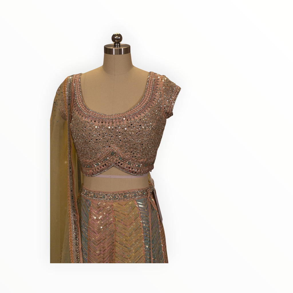 Zari Designs peach lehnga with intricate silver mirror work embroidery and chevron patterned skirt on a mannequin