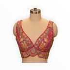 Zari Designs Carnival Lehnga blouse in vibrant pink with intricate multi-colored floral embroidery and sequin detailing.