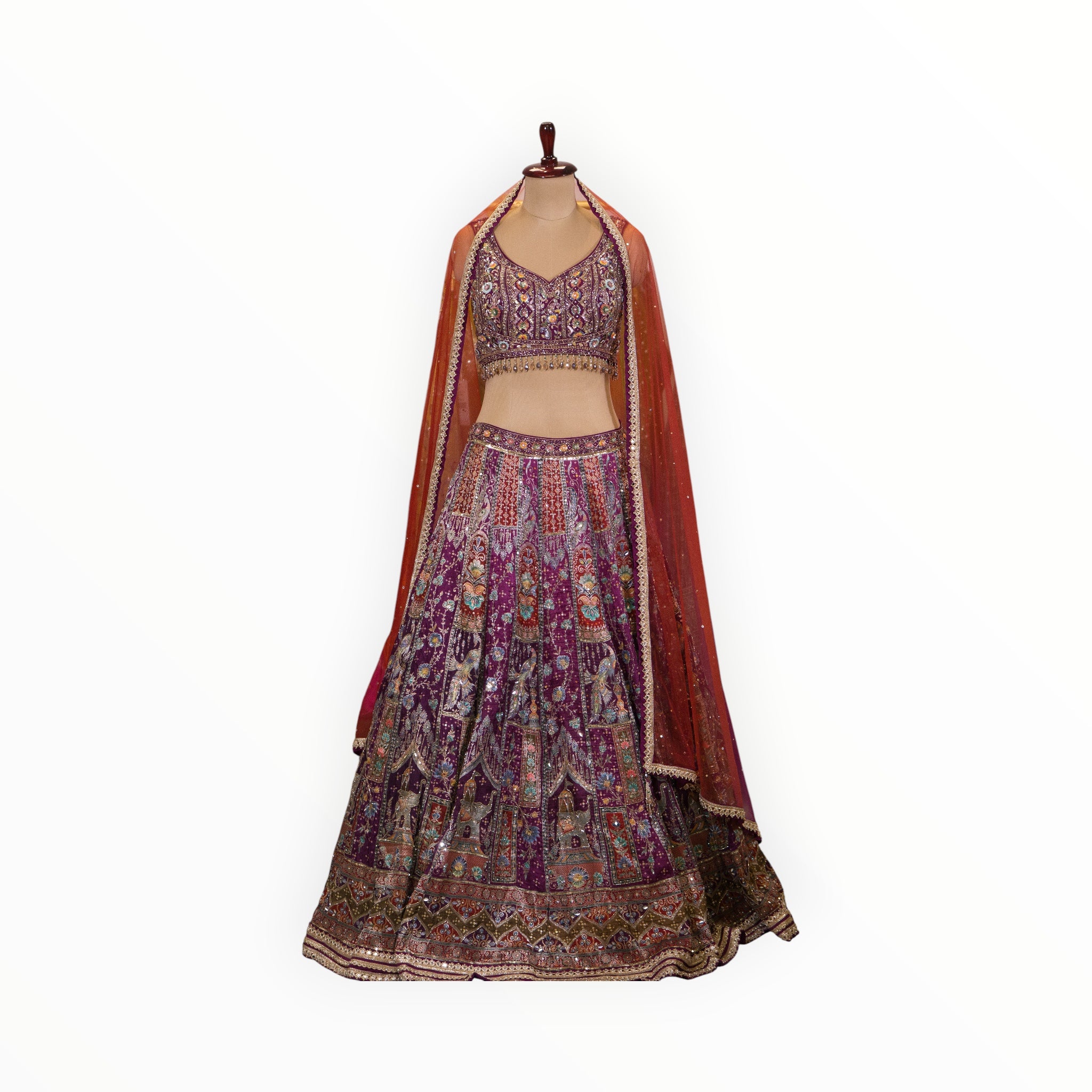 Zari Designs purple Banarsi lehenga with intricate embroidery, sequin work, and a sheer orange dupatta on a mannequin