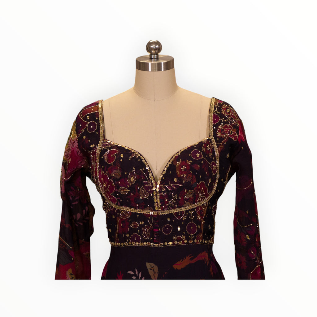 Zari Designs Anarkali dress featuring a deep purple floral print, sweetheart neckline, and intricate gold embroidery.