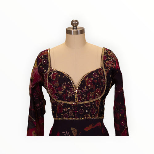 Zari Designs Anarkali dress featuring a deep purple floral print, sweetheart neckline, and intricate gold embroidery.
