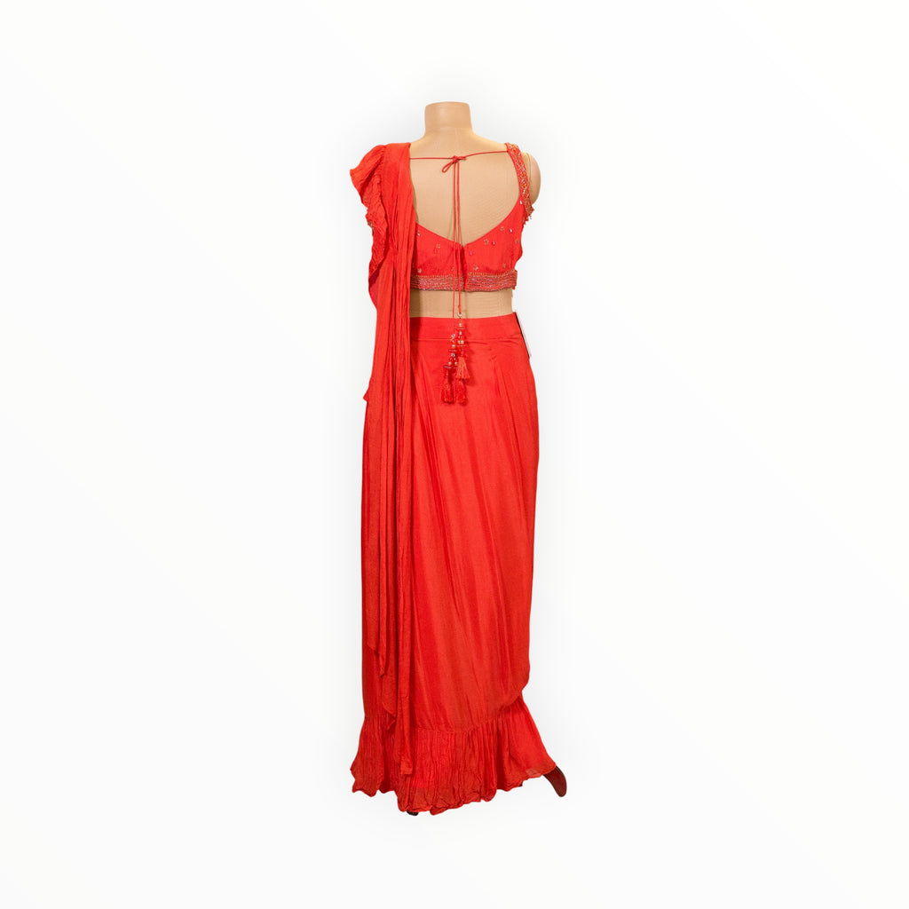 Back view of a Zari Designs red ready-to-wear saree with a sleeveless blouse, featuring delicate embroidery and tassels.