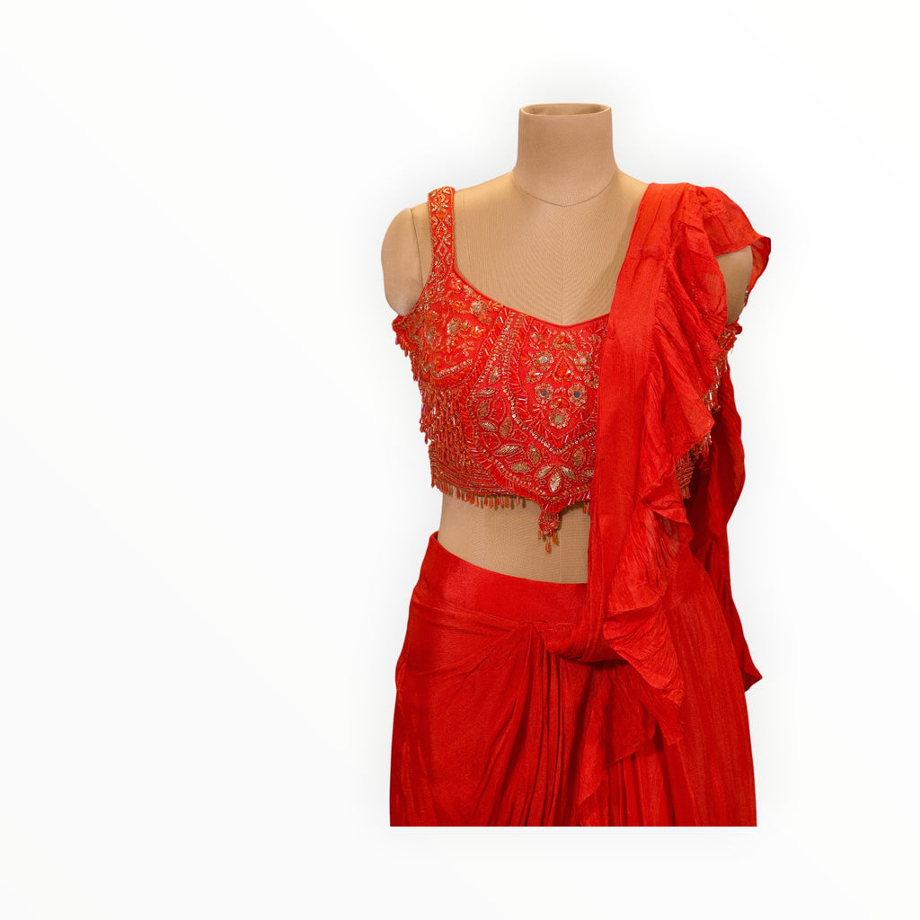 Zari Designs red ready-to-wear saree with a heavily embroidered sleeveless blouse and ruffled pallu drape.